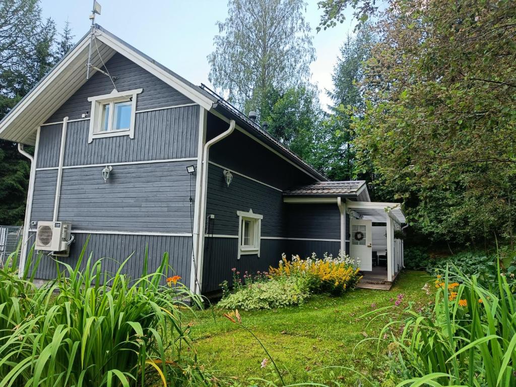 una casa nera con un giardino di fronte di Villa Perttilä 