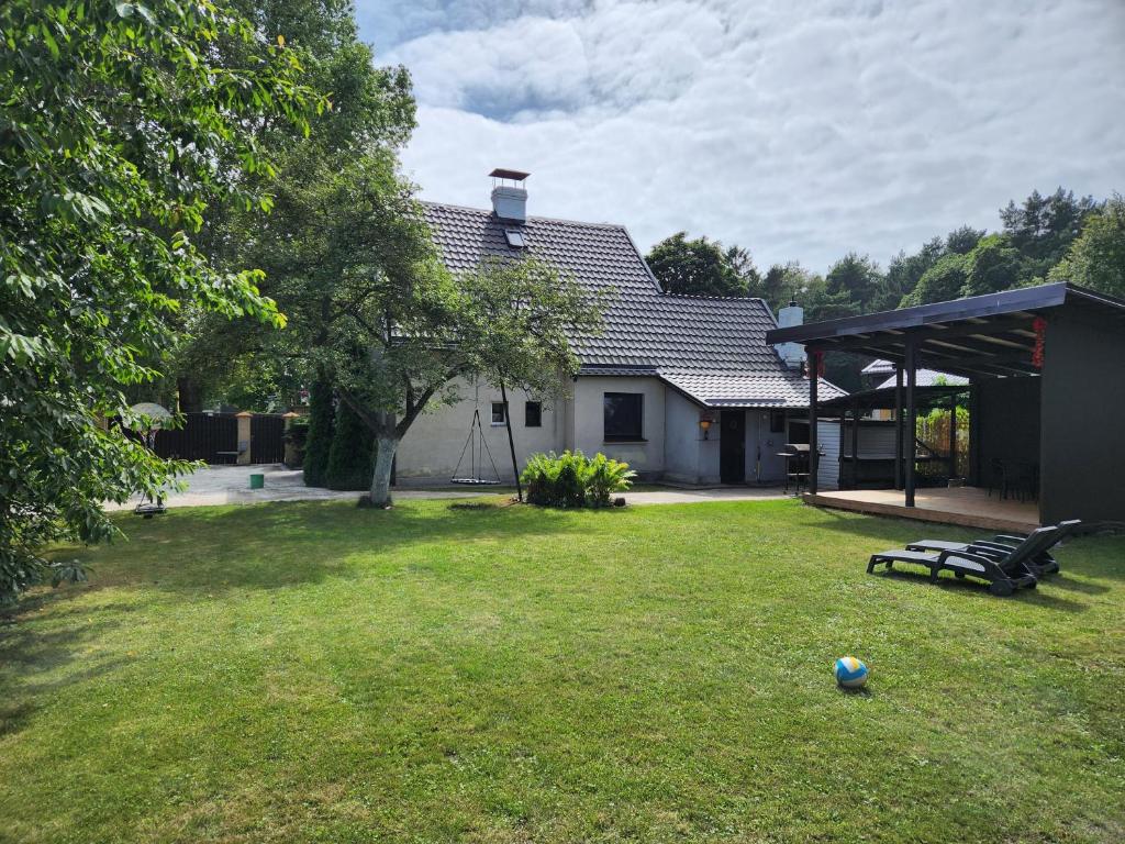 a house with a yard with a bench and a soccer ball at Svetes house - Garden & BBQ & Parking in Liepāja