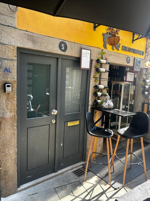 a door of a store with two chairs and a table at Casa Dentro da Vila in Ponte de Lima