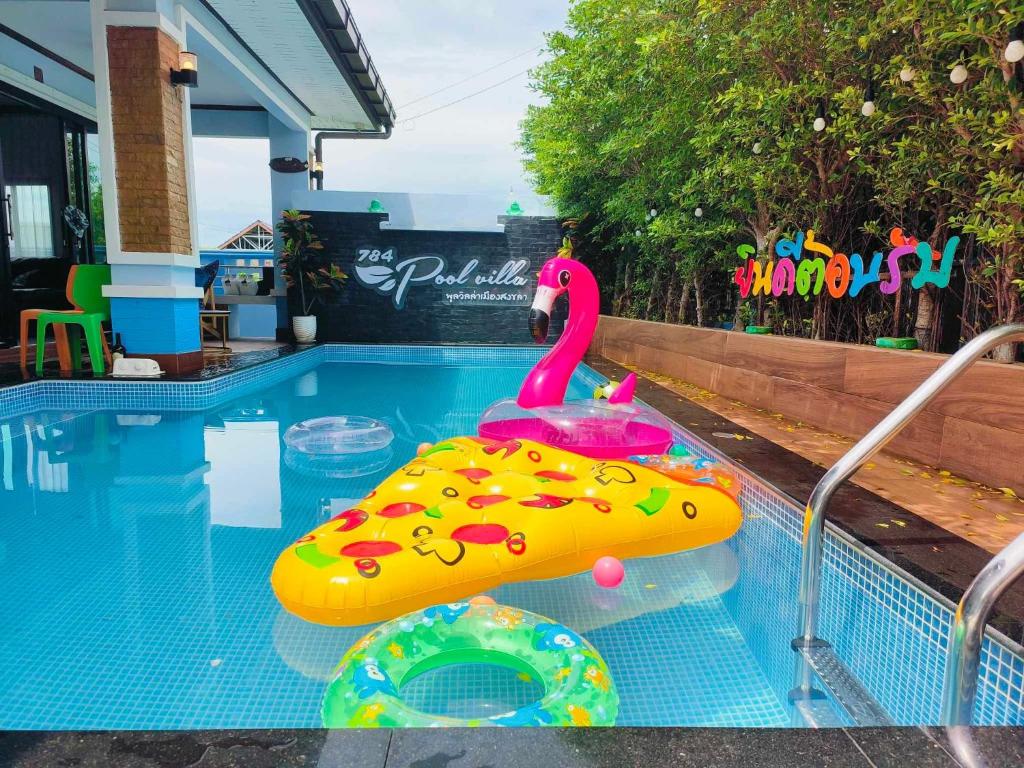 a swimming pool with a pink plastic swan in a toy at 784 poolvilla พูลวิลล่า in Ban Khao Rup Chang