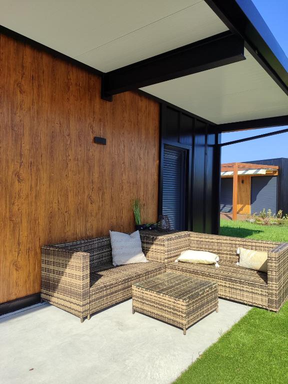 a wicker couch sitting on a patio at Cabañita Playa da Lanzada in Sanxenxo