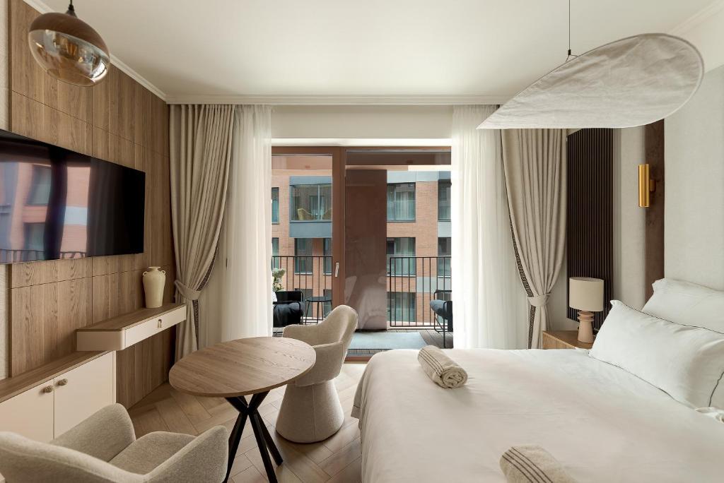 a bedroom with a bed and a table and chairs at Chmielna 2025 Premium Apartment Wyspa Spichrzów in Gdańsk