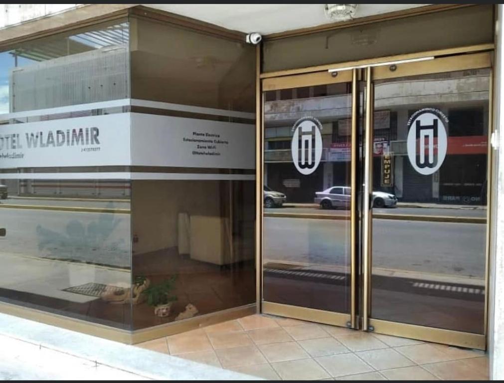 Un escaparate con puertas de cristal con un reflejo de la calle. en Hotel WLADIMIR, en Maracay