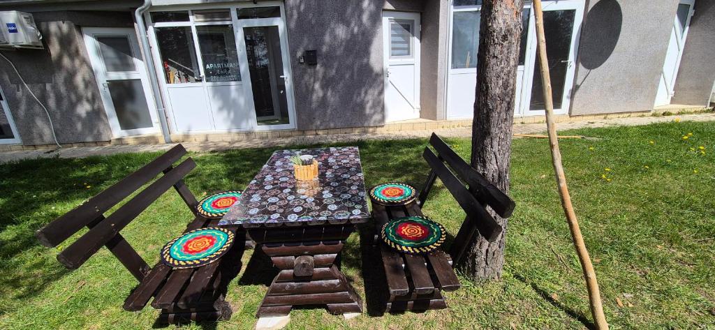 a picnic table in the grass next to a house at Apartman Anka in Divčibare