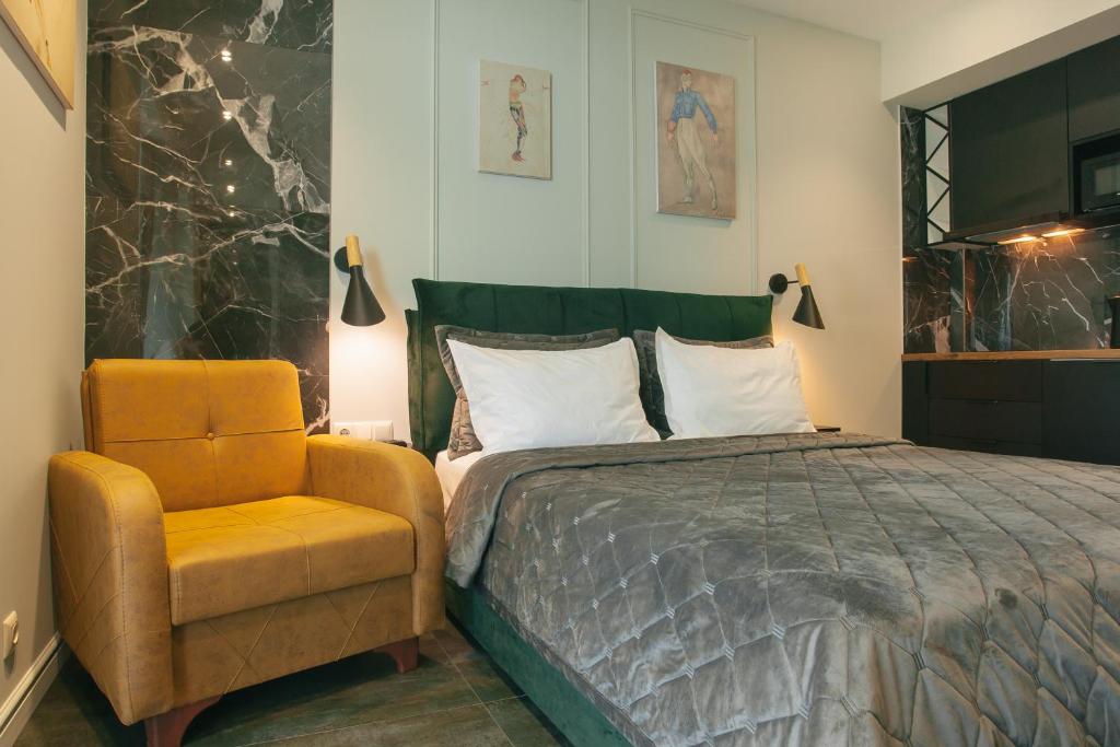 a bedroom with a bed and a chair at Beach Apartment in Batumi