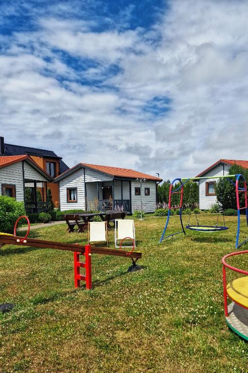 a park with a playground with a swing at Domek Standard 2 in Darłowo