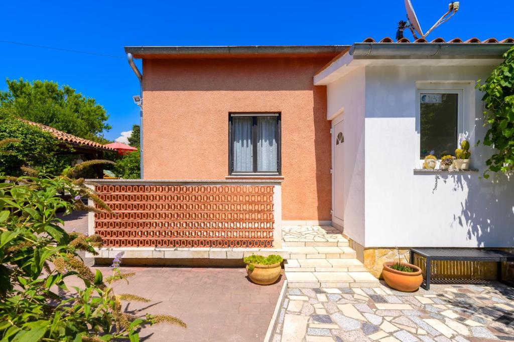 a house with a brick wall and a window at Apartments Villa Sabina in Pula
