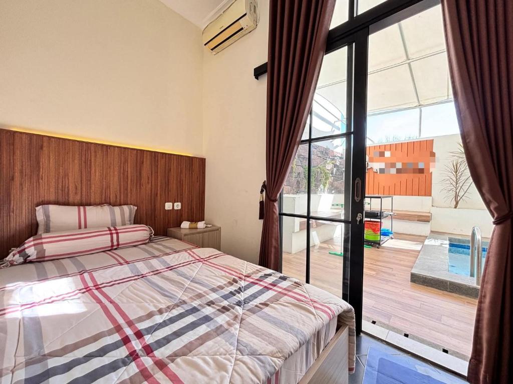 a bedroom with a bed and a large window at Villa Asri in Sarangan
