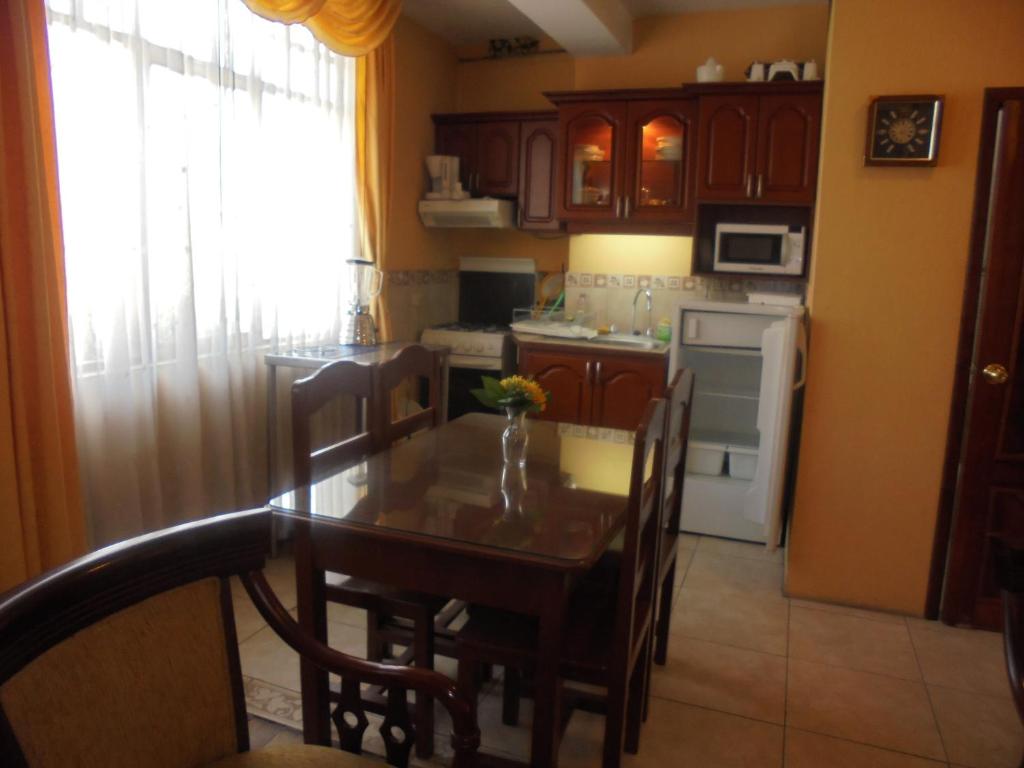 a kitchen with a table and chairs and a kitchen with a refrigerator at Chimborazo in Riobamba