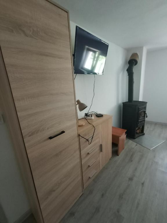 a large wooden cabinet with a television on top of it at Apartmán KPS in Kalameny