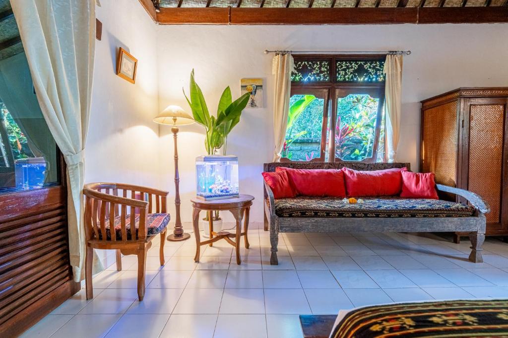 a living room with a couch and a window at Pondok Alami - House of Nature in Ubud