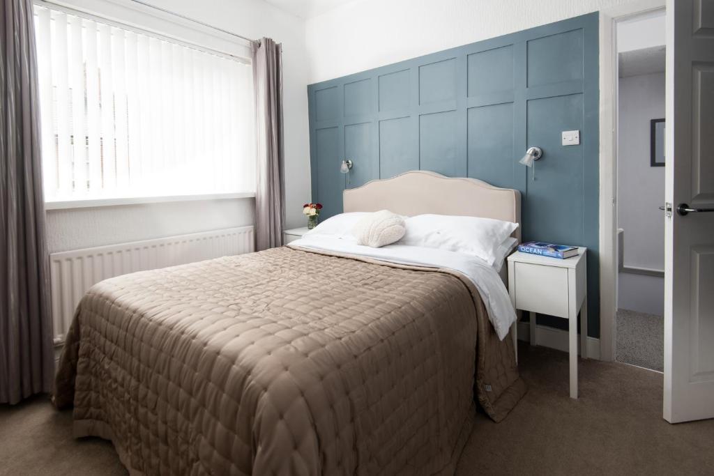 滨海纽比金Peaceful Coastal Home in Northumberland we are Pet Friendly Nov to Mar的卧室里有一张带蓝色床头板的大床