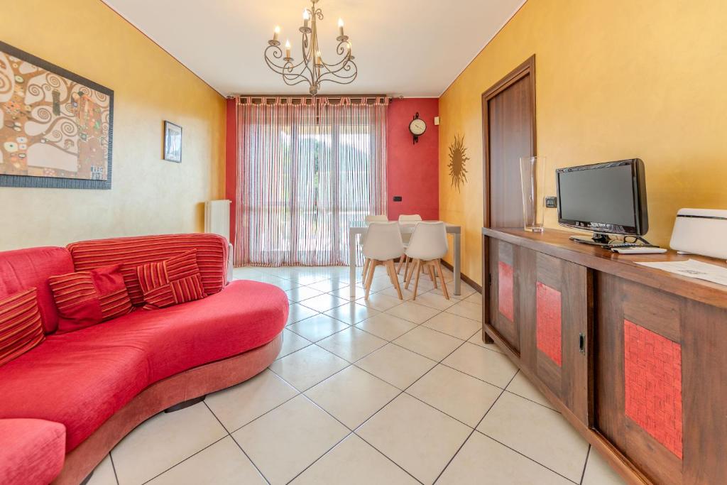 a living room with a red couch and a tv at Bnb Green in Cesate
