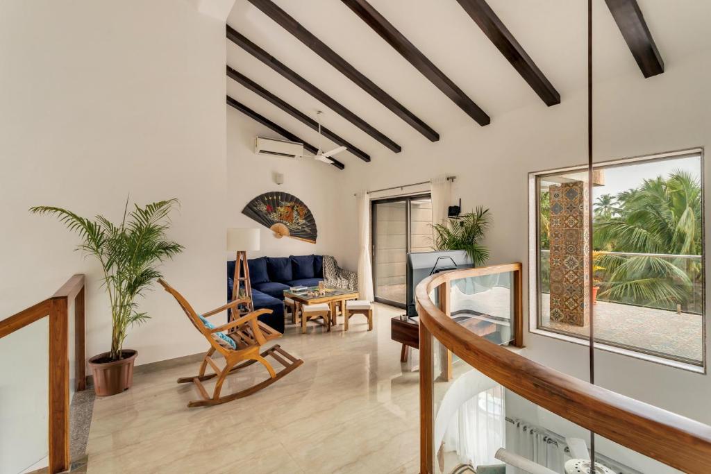 una sala de estar con un sofá y una silla en Luxury 3bhk penthouse Candolim beach 10 mins, en Goa