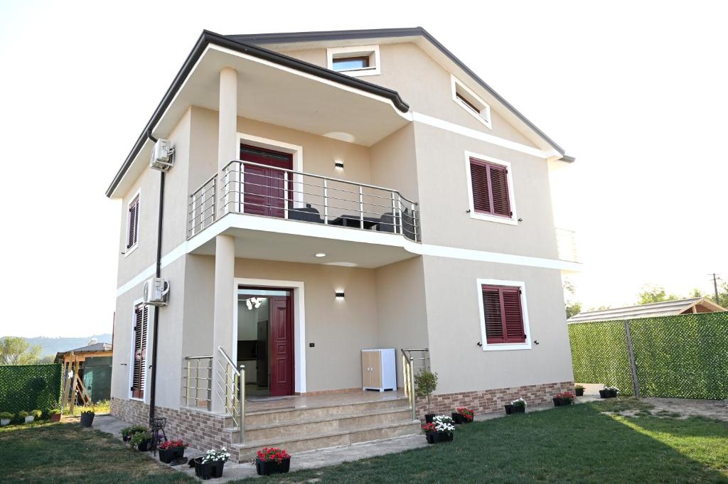uma casa branca com uma varanda em Fly Rooms em Krujë