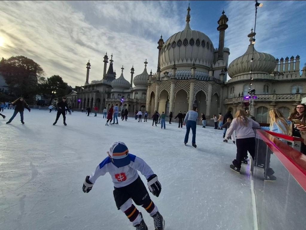 ブライトン＆ホーブにあるBeachfront, 2-bedroom, Sleeps 5, long staysの建物の前でアイススケートをしている人々のグループ