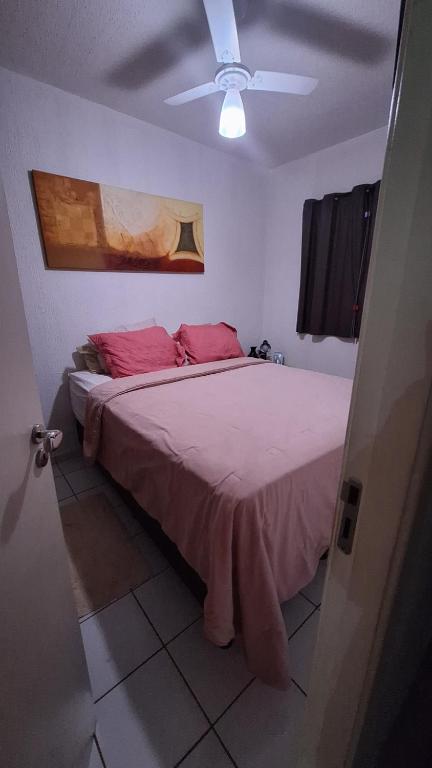 ein Schlafzimmer mit einem großen Bett mit rosa Kissen in der Unterkunft Condomínio Liberdade in Sao Jose do Rio Preto