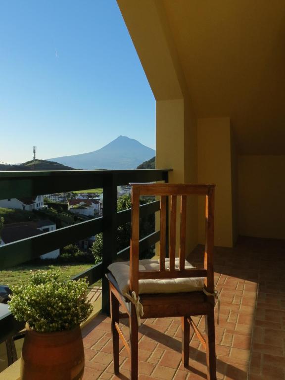 a wooden chair sitting on a balcony with a view at Quinta do Avô Brum in Flamengos