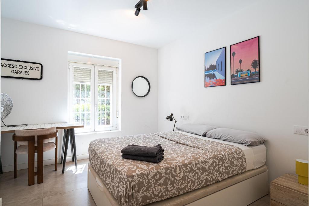 a white bedroom with a bed and a desk at Tu casa en Madrid in Madrid