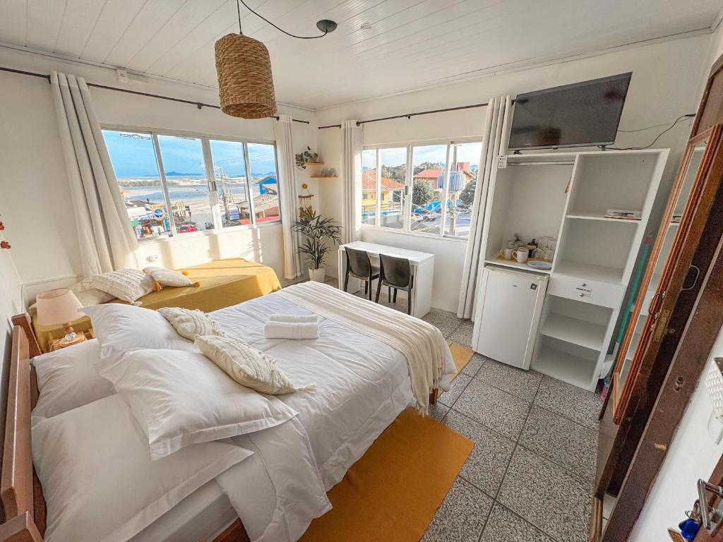 a bedroom with a bed and a view of the ocean at Pousada Surf na Guarda in Guarda do Embaú