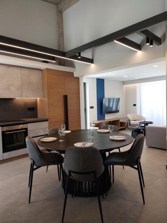 a dining room with a table and chairs and a kitchen at Hesperian Luxury Villas in Chania Town