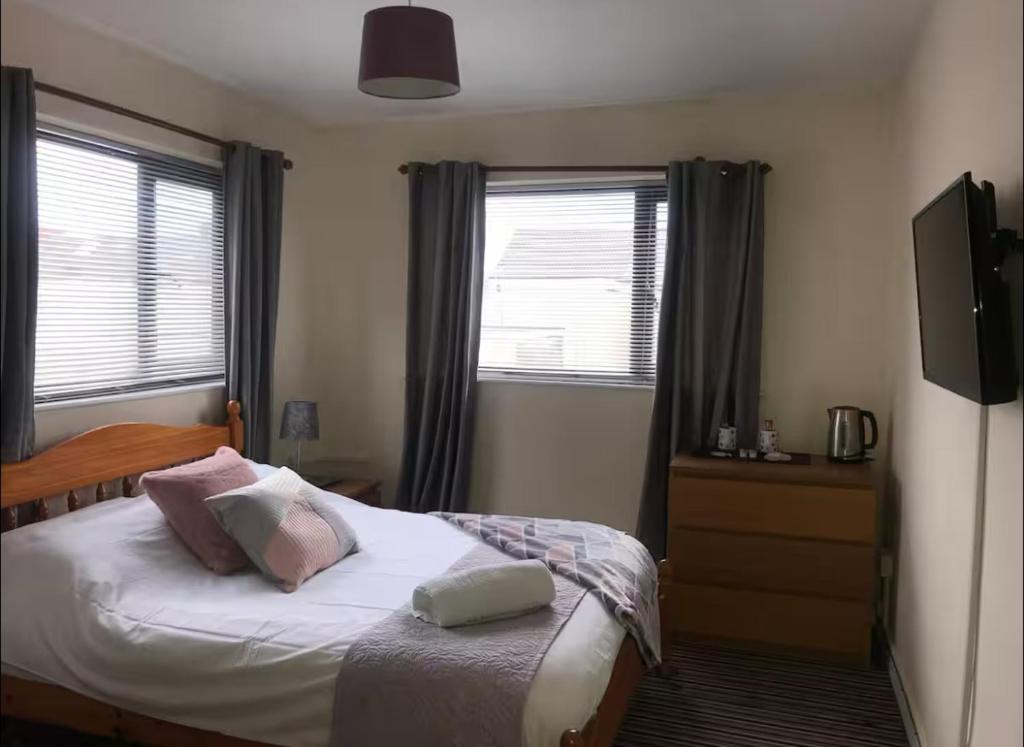 a bedroom with a bed with two pillows on it at 284 - Room 3 - Beachfront in Swansea