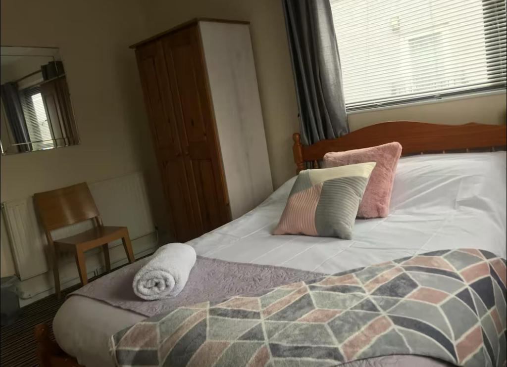 a bedroom with a bed with pillows and a window at 284 - Room 3 - Beachfront in Swansea