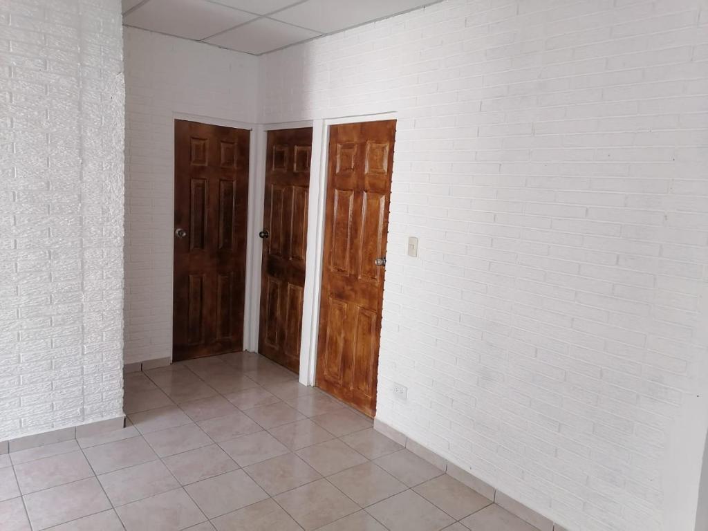Hostal Blanquita في سان سلفادور: غرفة فارغة ذات بابين وأرضية من البلاط