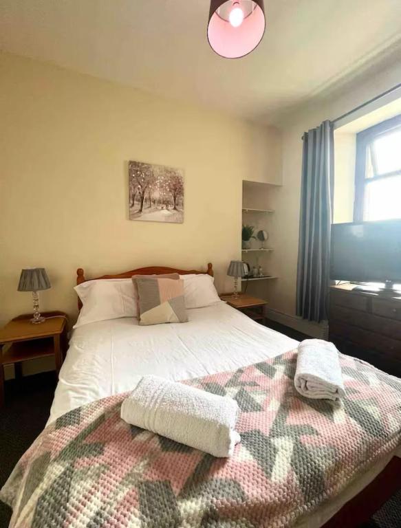 a bedroom with a bed with two towels on it at 284 - Room 4 - Beachfront in Swansea