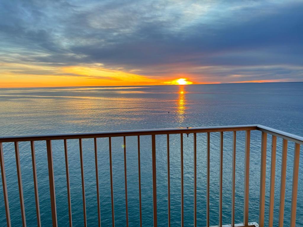 von einem Balkon mit Blick auf das Meer und den Sonnenuntergang in der Unterkunft Vista al mar con piscina in Faro de Cullera