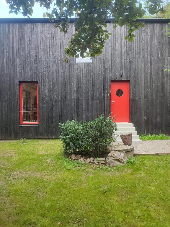 a house with a red door and a fence at Romantic cottage Slapy - Renovated in Brunšov