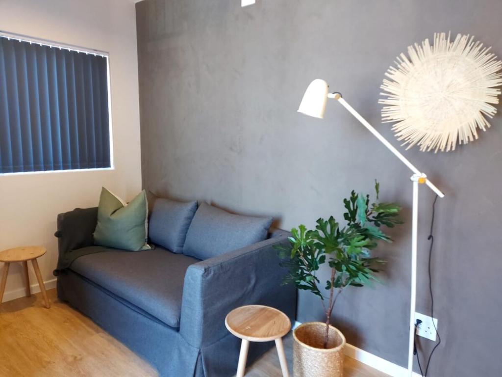 a blue couch in a living room with a plant at 212 The Meadows in George