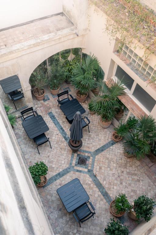 an overhead view of a patio with tables and plants at la Maison Molière in Arles