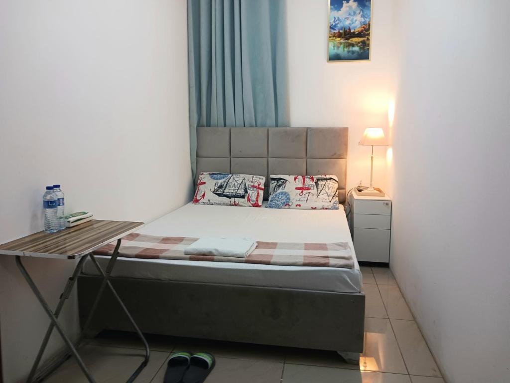a small bedroom with a bed and a desk at Dragon Golden Homes in Dubai