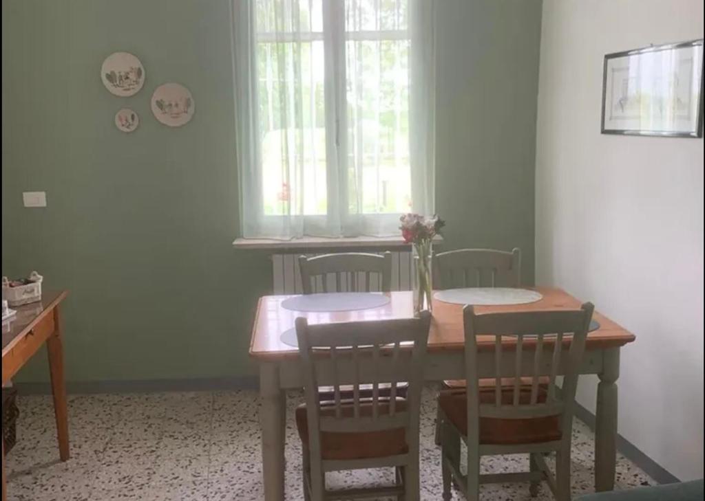 a dining room table with chairs and a vase of flowers on it at La casa di AnNa in Cervesina