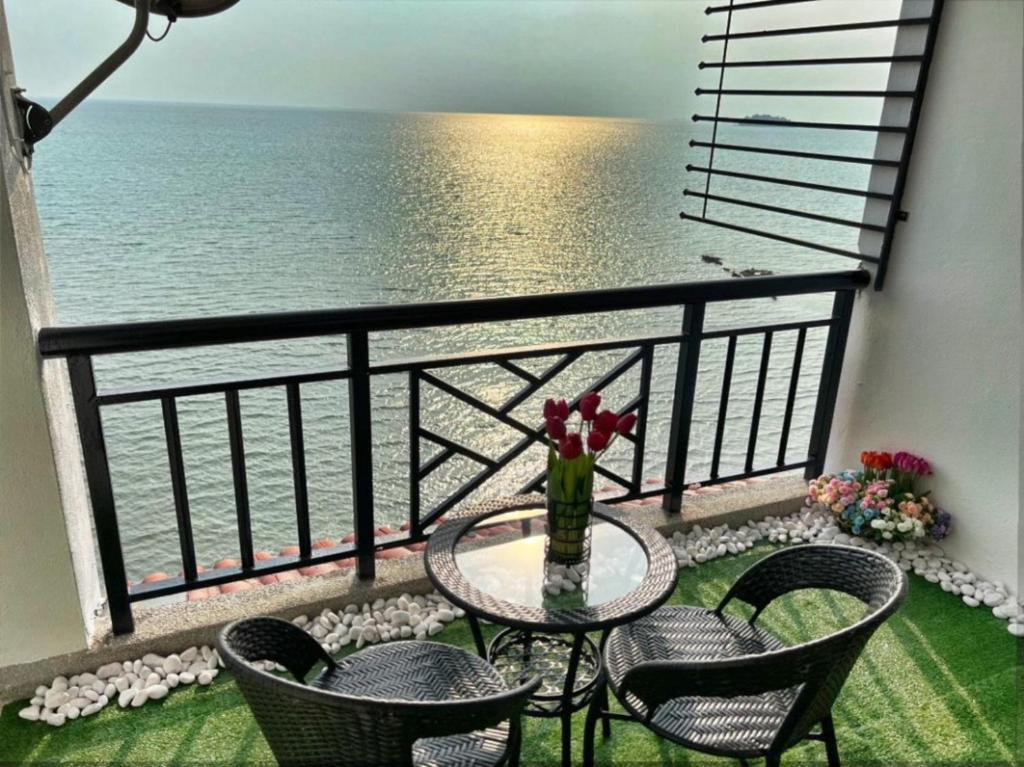 a balcony with a table and chairs and the ocean at PD Paradise Lagoon Apartment in Port Dickson