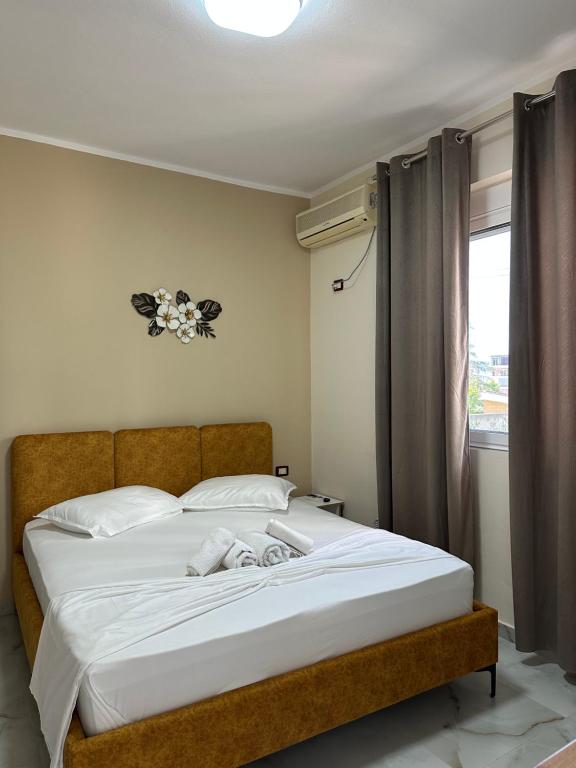 Un dormitorio con una gran cama blanca con ventana. en Hotel Ridal, en Vlorë