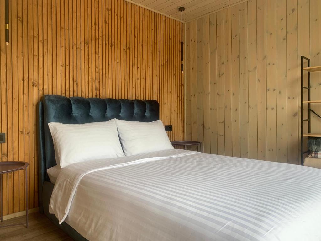 a bedroom with a large bed with a blue headboard at Aurora Resort in Stasiūnai