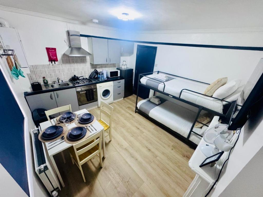 a small room with a bunk bed and a kitchen at Stylish 1BR Flat Kings Cross, Central London in London
