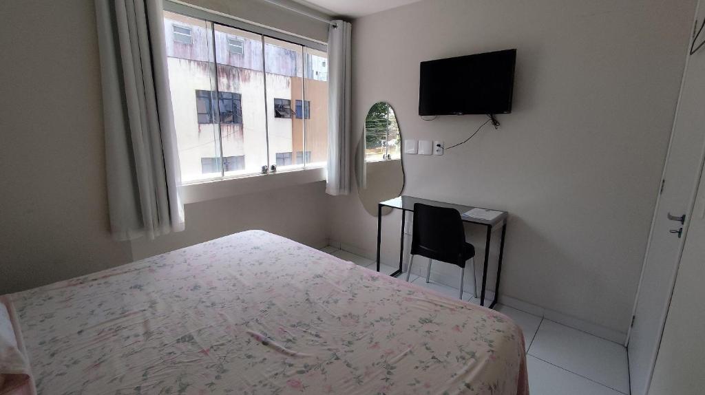 a bedroom with a bed and a tv and a window at AP Completo em Garanhuns vista avenida (104) in Garanhuns