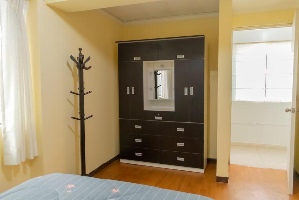 ワラスにあるAmplio departamento 3 dorm-Centro Huarazのベッドルーム(黒いドレッサー、鏡付)