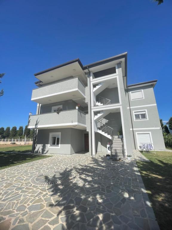 a white building with a staircase in front of it at Sol Apartments in Lezhë