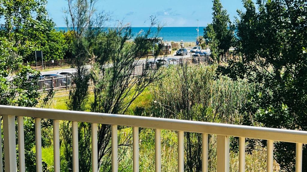 a balcony with a view of a parking lot and the ocean at Alba sul mare in Marina di Montenero
