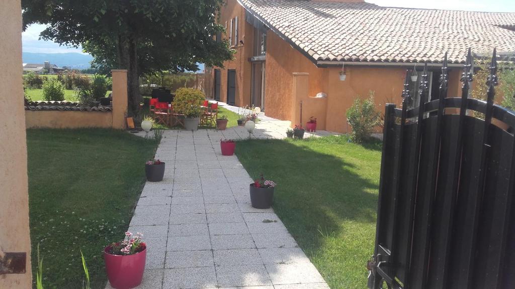 a walkway in a yard with potted plants at La Clé Des Champs in Chabeuil