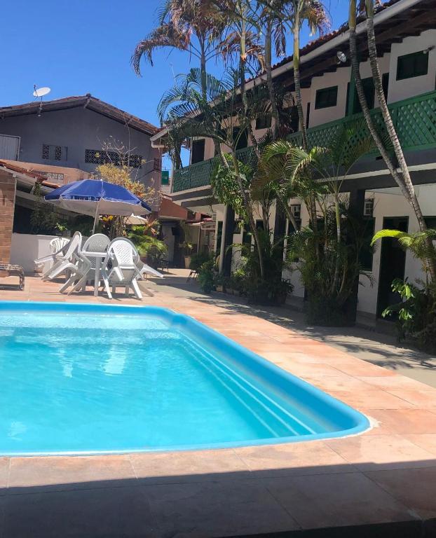 a swimming pool in front of a house at Pousada Tapuia in Porto Seguro
