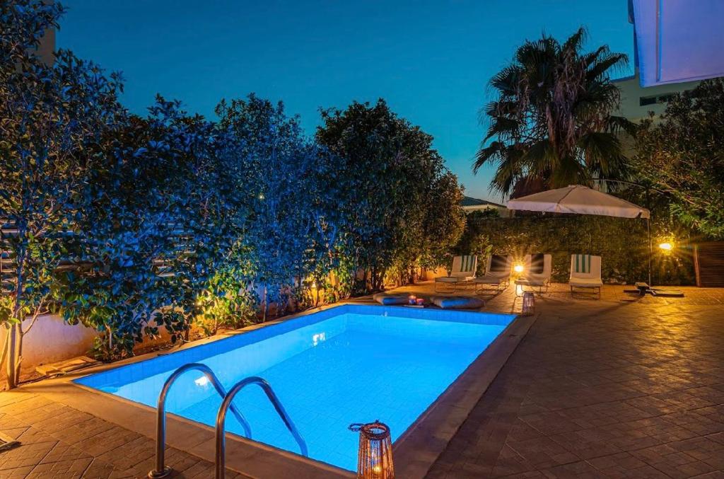 a swimming pool in a backyard at night at Βίλα Λαγονήσι in Kalívia Thorikoú