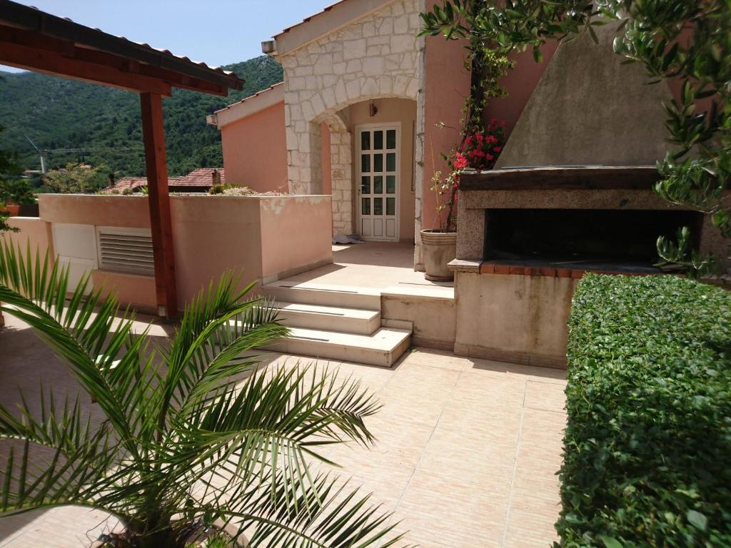 un patio de una casa con puerta y escaleras en Apartments Leko, en Žuljana