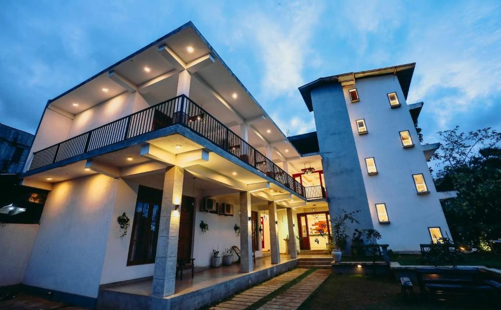 a large white building with a balcony and stairs at Kudila Resort in Anuradhapura