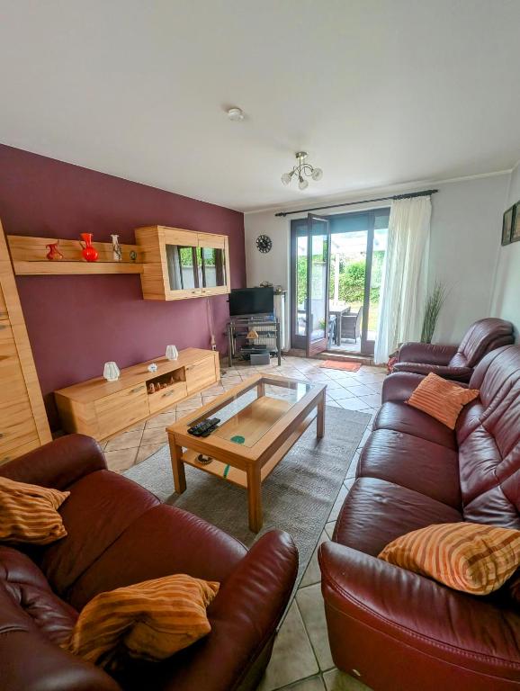 a living room with a leather couch and a coffee table at Ferienhaus Thomm in Konz