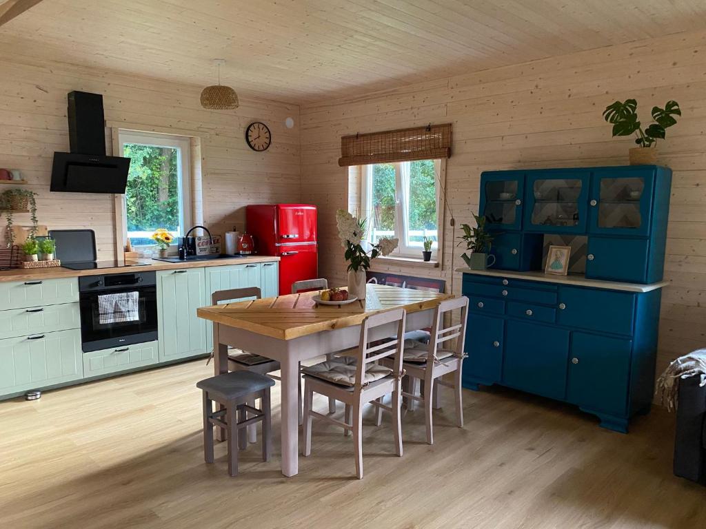 a kitchen with blue cabinets and a table and chairs at Osada California in Grudna